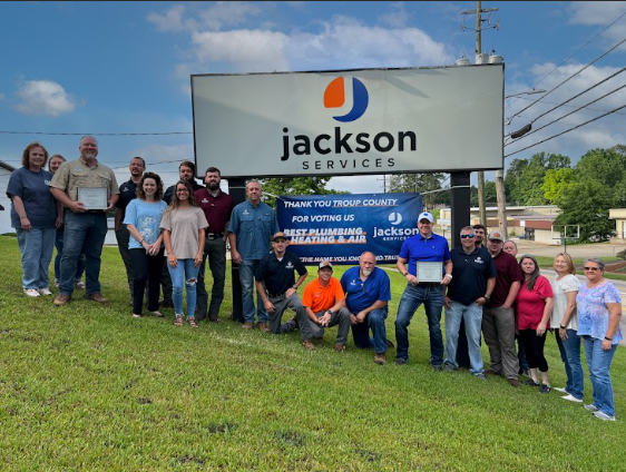 jackson services staff standing next to jackson services sign