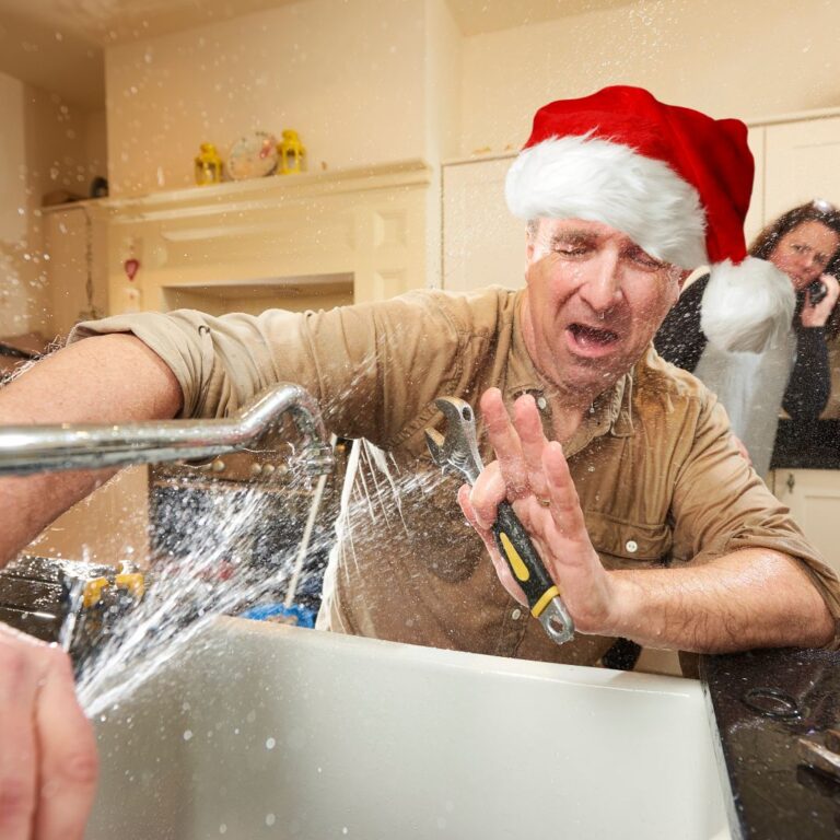 man wearing santa hat with sink spraying at him