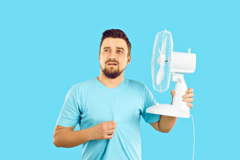 man inside pointing fan at self